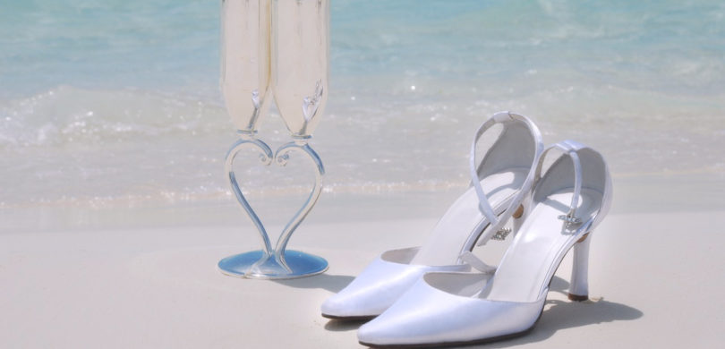 Bridal Shoes and Bridal Champagne Glasses on the Beach